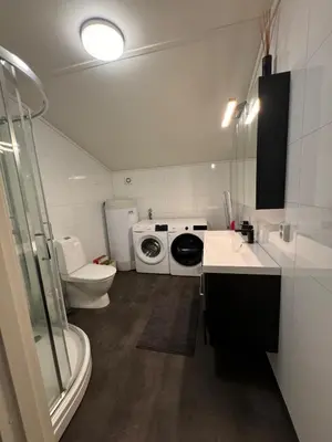 a bathroom with a washing machine and a toilet at Steinkjer, 5 room apartment in Steinkjer
