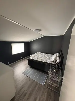 a bedroom with a bed in a room with a window at Steinkjer, 5 room apartment in Steinkjer
