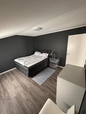 a bedroom with a bed in a black wall at Steinkjer, 5 room apartment in Steinkjer