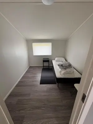 a small room with a bed and a window at Steinkjer, 5 room apartment in Steinkjer