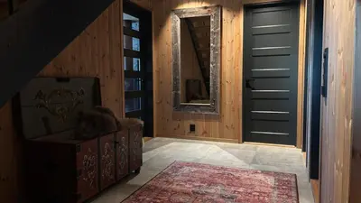 a hallway with a black door and a rug at Modern and cozy mountain cabin - panoramic view! in Torvetjørn