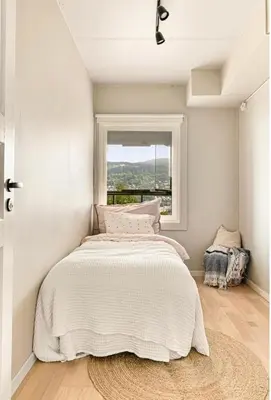 a bedroom with a large bed with a window at Solheimslien in Bergen