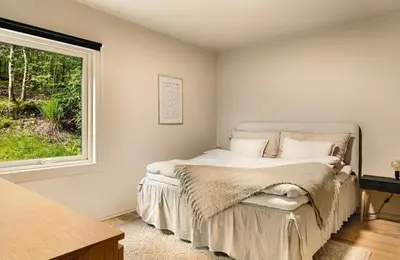 a bedroom with a bed and a window at Solheimslien in Bergen