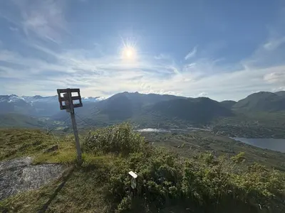 a sign on the side of a mountain with a view at Modern cottage in the heart of the Sunnmøre Alps in Sykkylven