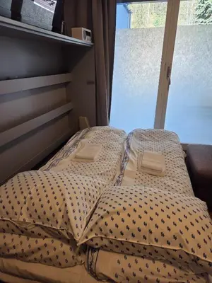an unmade bed in a bedroom with a window at 