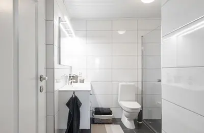a white bathroom with a toilet and a sink at Mountain Dream in Vossevangen