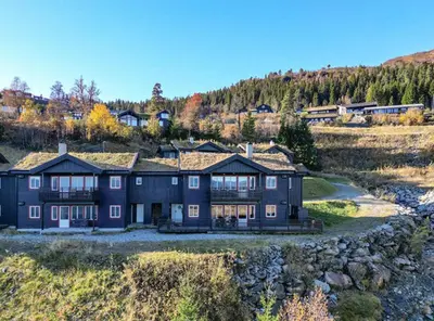 a large blue house on top of a hill at Mountain Dream in Vossevangen