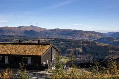 a large building with mountains in the background at Mountain Dream in Vossevangen