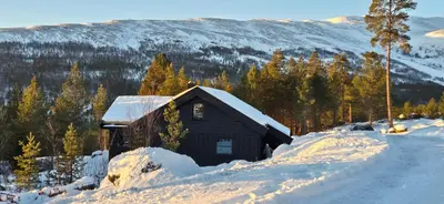 a small cabin covered in snow on a snow covered road at Elegantes, ruhiges Ferienhaus in bester Lage für alle Outdoorfans in Randsverk
