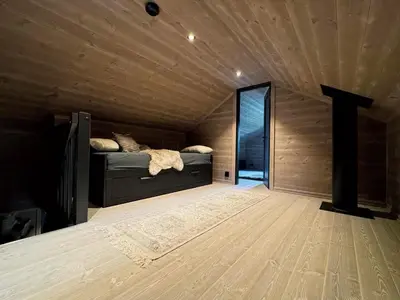 a bedroom with a bed in a room with wooden walls at Elegantes, ruhiges Ferienhaus in bester Lage für alle Outdoorfans in Randsverk
