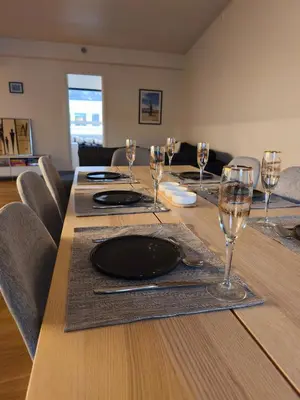a table with wine glasses and a plate on it at Modern 3-Bedroom Apartment in Central Voss - Prime Location in Vossevangen