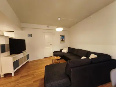 a living room with a black couch and a flat screen tv at Modern 3-Bedroom Apartment in Central Voss - Prime Location in Vossevangen