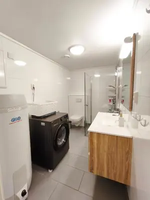 a bathroom with a washer and a sink and a washing machine at Modern 3-Bedroom Apartment in Central Voss - Prime Location in Vossevangen