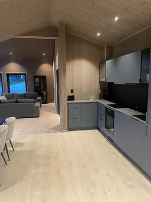 a kitchen and living room with a couch and a table at Fjellro Budor - ski in ski out in Løten