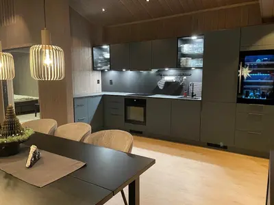 a kitchen with a black table and chairs and a kitchen withilitation at Fjellro Budor - ski in ski out in Løten