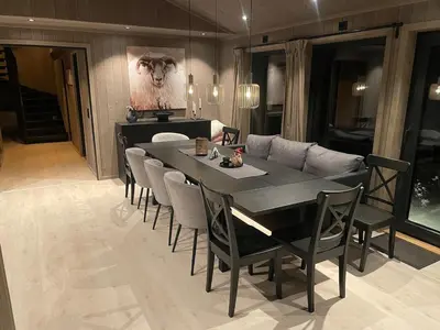 a dining room with a table and a couch at Fjellro Budor - ski in ski out in Løten