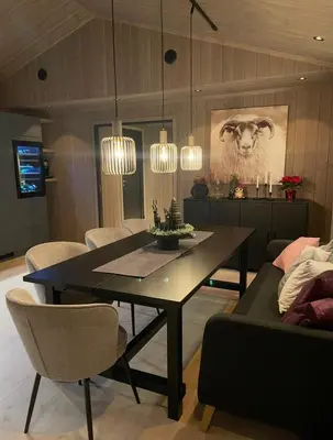a dining room with a table and a couch at Fjellro Budor - ski in ski out in Løten