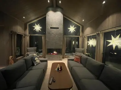 a living room with a couch and a fireplace at Fjellro Budor - ski in ski out in Løten