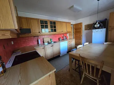a kitchen with wooden cabinets and a table with chairs at Brendefur Panorama in Hornindal