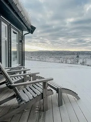 a wooden bench sitting on the porch of a house at Modern Cabin With Views Of Langsua National Park in Etnedal