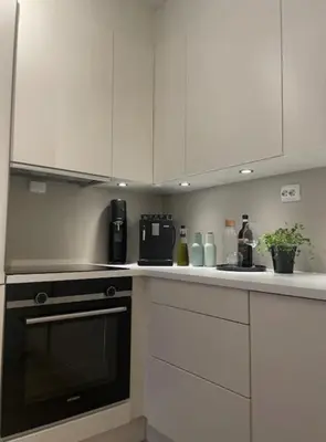 a kitchen with white cabinets and a black oven at Workinntoppen in Lii