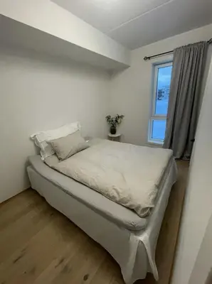 a white bedroom with a bed with a window at Workinntoppen in Lii