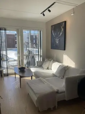 a living room with a white couch and a table at Workinntoppen in Lii