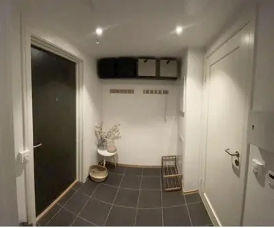 a hallway with a room with a door and a staircase at Workinntoppen in Lii