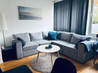 a living room with a couch and a table at Central Apt - Steps to Fish Market and Bryggen in Bergen