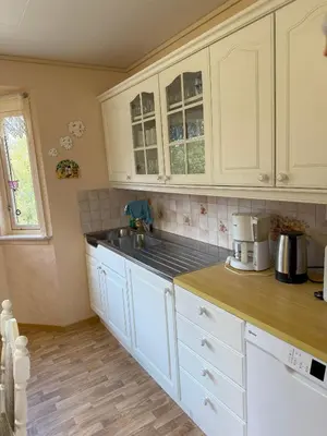 a kitchen with white cabinets and a sink at Great House with a panoramic view in Storsæter