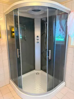 a shower with a glass door in a bathroom at Great House with a panoramic view in Storsæter