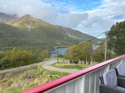 a balcony with a view of a lake and mountains at Great House with a panoramic view in Storsæter