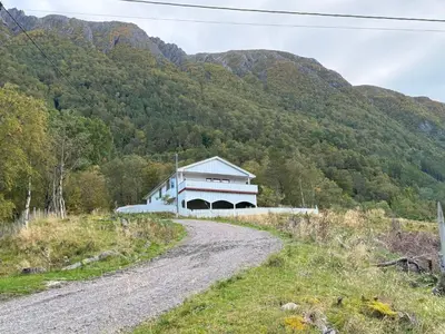 a house on a dirt road in front of a mountain at Great House with a panoramic view in Storsæter