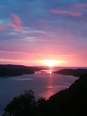 a sunset over a large body of water at Great House with a panoramic view in Storsæter