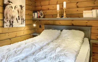 a large bed in a room with wooden walls at Pet Friendly Home In Bjorli With Sauna in Bjorli
