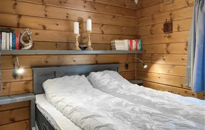a large white bed in a room with wooden walls at Pet Friendly Home In Bjorli With Sauna in Bjorli