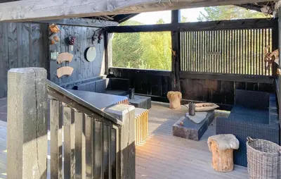 a porch with a wooden deck with a bench and chairs at Pet Friendly Home In Bjorli With Sauna in Bjorli