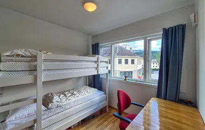 a bedroom with bunk beds and a table and a window at Awesome Apartment In Ulvik With House Sea View in Ulvik