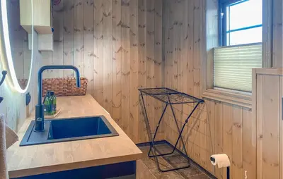 a kitchen with a sink and a wooden wall at 3 Bedroom Beautiful Home In Lesjaverk in Bjorli