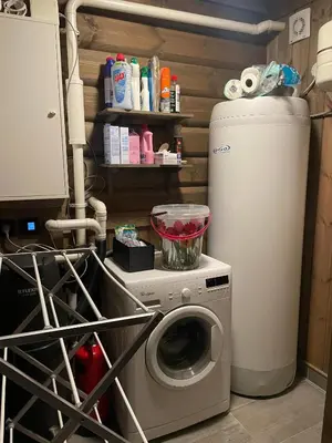 a laundry room with a washing machine and a refrigerator at Fjellhytte Med 4 Soverom, Sauna, Peis Og Terrasse in Beitostøl
