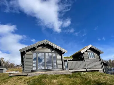 a small house on top of a grassy hill at Fjellhytte Med 4 Soverom, Sauna, Peis Og Terrasse in Beitostøl
