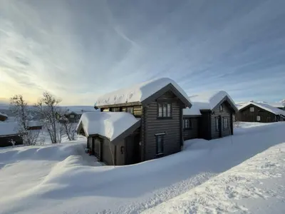 a cabin in the snow with snow on the roof at Fjellhytte Med 4 Soverom, Sauna, Peis Og Terrasse in Beitostøl
