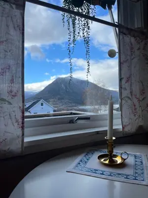 a candle sitting on a table in front of a window at Home with a view in Lom