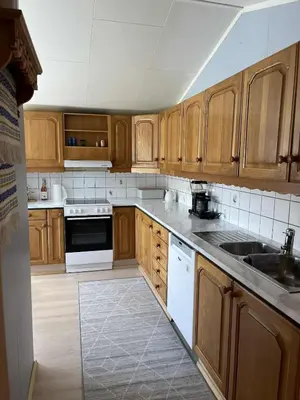a kitchen with wooden cabinets and white appliances at Home with a view in Lom