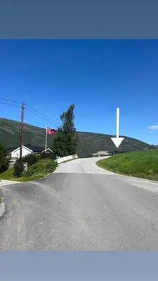 an empty road with a cross in the distance at Home with a view in Lom
