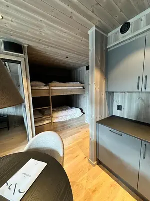 a kitchen with a table and a room with bunk beds at New apartment in Hemsedal Fjellandsbyen in Hemsedal