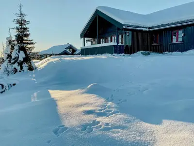 a pile of footprints in the snow in front of a house at Cosy Cabin By Golsfjellet Ski Resort in Gol