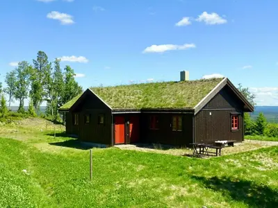 a small house with a grass roof on a field at Cosy Cabin By Golsfjellet Ski Resort in Gol