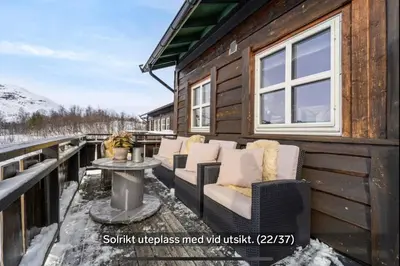 a cabin deck with chairs and a table at Hovden Alpin Apartments in Bykle