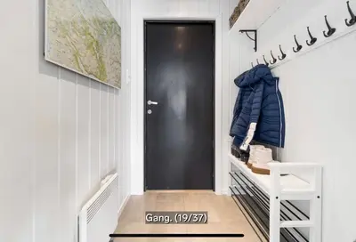 a hallway with a black door and a white staircase at Hovden Alpin Apartments in Bykle